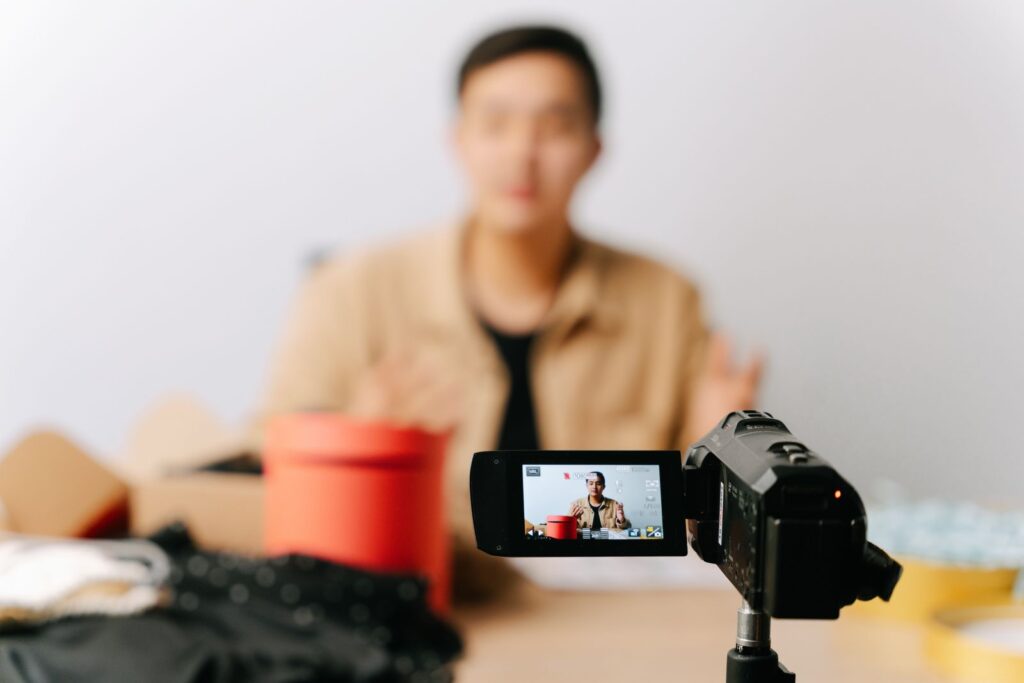 Content-Creator sitzt vor Videokamera im Studio