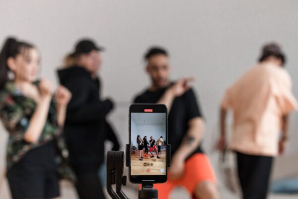 Gruppe dreht Reel mit Smartphone auf Stativ