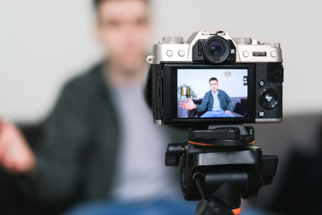 Creator filmt sich mit Kamera auf Stativ