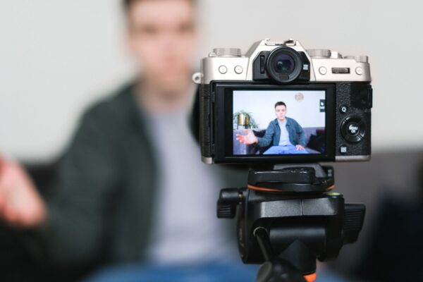 Creator filmt sich mit Kamera auf Stativ
